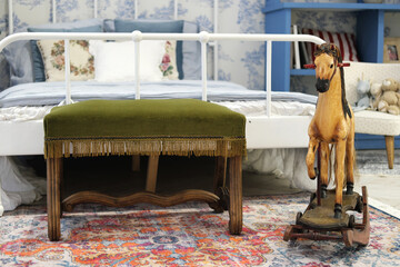 Wall Mural - Christmas interior of a children's room in vintage style and blue colors. The bedside table and the rocking horse stand in the foreground