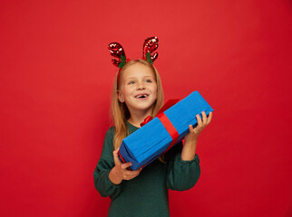 Wall Mural - Smiling funny child (kid, girl) in Reindeer Hairband