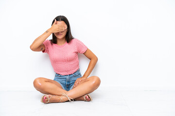 Wall Mural - Young caucasian woman sitting on the floor isolated on white background covering eyes by hands. Do not want to see something