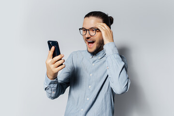 Wall Mural - Studio portrait of young happiness man using smartphone on white background.