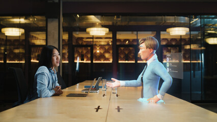 Video call chat conference of an asian woman using hologram technology. Conversing with a cartoon character avatar of young man. Advanced technology. VFX. Augmented reality.