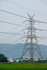 Sticker - Vertical shot of a big transmission tower with wires in a rural area in daylight