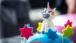 Closeup shot of an edible unicorn and colorful stars on a cake