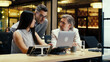 © Framestock - Diverse creative office workers talking and having working conference in modern office, using laptop and digital tablet. Businesspeople working on startup project. Discussion of company strategy