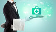 © ra2 studio - Handsome young waiter in tuxedo holding healthcare icons on tray