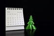 Selective focus of December 2022 desk calendar on dark black background with christmas tree and copy space.