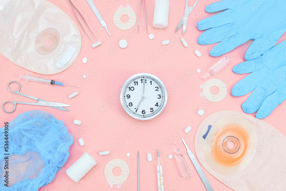 Surgeon's kit for surgery with a watch and a colostomy bag on a soft pink background.