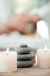 Spa, rock and candle to relax in a room with atmosphere, mood or ambience in a health club. Wellness, luxury and treatment with still life objects on a table in a clinic for rest and relaxation
