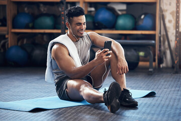 Poster - Man, exercise and phone on social media with smile rest on floor in gym during training session. Guy, wellness and smartphone take break during workout for fitness, health and sport with happiness