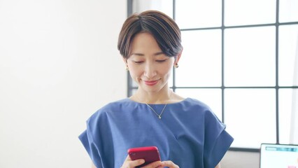 Leinwandbilder - スマホを見ながら室内を歩く女性