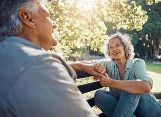 Wall Mural - Elderly, couple and happy on bench in garden for conversation, bonding and happiness by trees in summer. Man, woman and retirement show love, relax and smile together in nature with sunshine at park