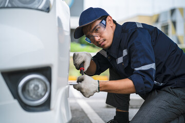Wall Mural - A mechanic in a safety suit is working on a damaged motor vehicle on site. Repair and Service Concepts .Professional car mechanic. service technician
