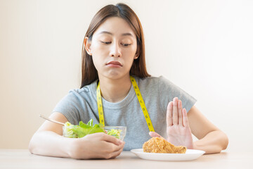 Wall Mural - Diet, Dieting asian young woman or girl push out, deny fried chicken, junk food and choose fresh vegetables salad of bowl, eat food for good healthy, health when hungry. Female weight loss people