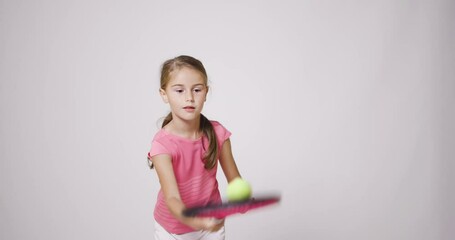 Wall Mural - Young female tennis player. Girl in pink sports outfit bouncing a ball.