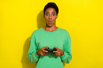 Wall Mural - Photo of impressed funky short hair human wear casual sweater holding playstation isolated yellow color background