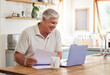 © Nina Lawrenson/peopleimages.com - Senior man, smile and laptop working in kitchen getting good news about income, investments or insurance at home. Happy elderly male investor reading email on computer for planning online retirement