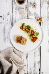 Wall Mural - Meat cutlets and appetizing grilled vegetables on a white plate. Grilled zucchini and carrots with herbs and spicy sauce. Delicious and healthy food. Top view. Copy space