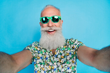 Poster - Selfie photo of pensioner grandfather wear stylish summer shirt toothy eyewear ray ban sunglass positive relax vacation isolated on blue color background