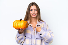 Young Pretty Woman Holding A Pumpkin Isolated On White Background With Surprise Facial Expression