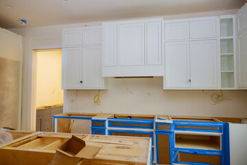 Wall Mural - In newly constructed house, white kitchen cabinets and furniture were installed as part of interior decoration