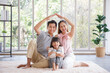 © aekkorn - Real estate and mortgage concept : Family with child having fun in new home. Joyful first-time buyers in living room. Real estate, residential mortgage, moving into dream house.