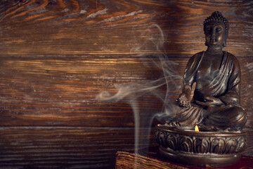 Spiritual still life of bronze Buddha statue and smoke of aroma sticks, Relaxation, meditation.