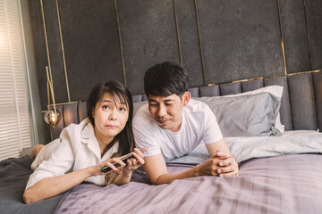 Wall Mural - marriage couple selfie on bed using smartphone. happy boyfriend lay near girlfriend watching fun application. romantic lover laying together relax on comfortable sheet smile living good relationship