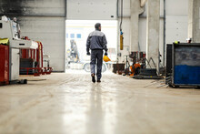 A Heavy Industry Worker Leaves His Workplace And Goes To The Exit Of The Factory.