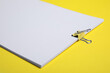© New Africa - Sheets of paper with clip on yellow background, closeup