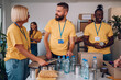 © Zamrznuti tonovi - Group of multiracial volunteers working in community charity donation center