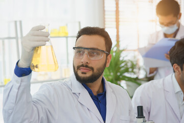 Middle Eastern man scientist expertise in laboratory research biology discovery test tube analyzing extract biotechnology examining.Doctor student learning medical pharmacy chemist lab scientific.