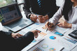 © amnaj - Group of business people meeting to plan, analyze, graph and chart corporate growth to plan new business expansions in the future.