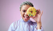 © N Felix/peopleimages.com - Black woman, donut and fashion excited and happy peeking through dessert with futuristic vaporwave and holographic style and purple background. Face portrait of cool and trendy African female model