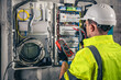 © puhimec - Man, an electrical technician working in a switchboard with fuses.