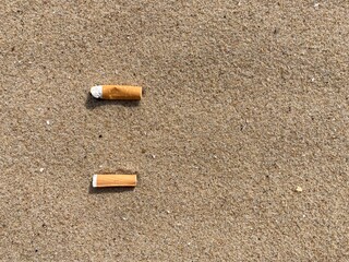 Aufkleber - two cigarette butts arranged as bullet points in sand on beach