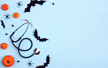 stethoscope and halloween decorations on blue background with copy space.