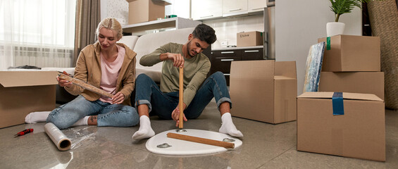 Sticker - Blonde girl and bearded man packing table on floor