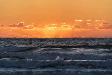 Wall Mural - Stunning Summer sunset landscape image of Widemouth Bay in Devon England with golden hour light ocean with shallow depth of field technique