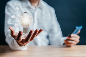 Aufkleber - Hand holding virtual lightbulb with cloud computing and technology icon. businessman using smart phone. Cloud management big data include business strategy, backup and upload data in network.