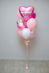 Wall Mural - A set of pink balloons on the background of the wall, decor from helium balloons, the inscription on the pink foil balloon heart 