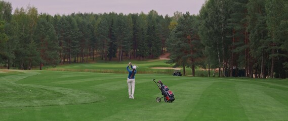 Caucasian female playing golf, striking a ball during the course