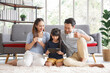 © aekkorn - Happy young asian family mom and dad with daughter having fun in liviing room at home, while daughter using tablet. Family,love and happiness concept.