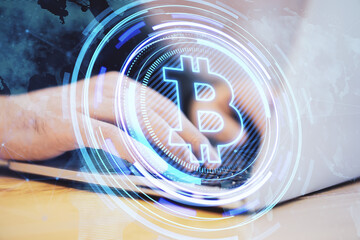Leinwandbilder - Close up of male hands at desktop using laptop with creative glowing bitcoin hologram and map on blurry background. Crytpocurrency, nft, metaverse and blockchain concept. Double exposure.