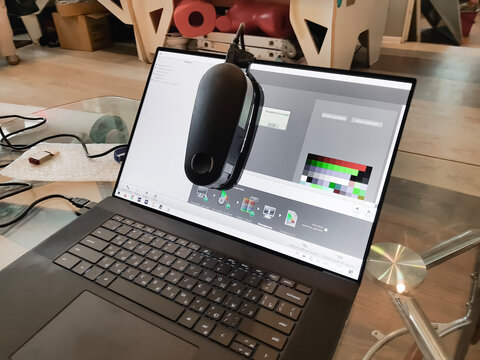 Calibration of laptop led white screen,monitor color.Computer display calibration for true accurate rgb colors.Photographer's workspace with attached self calibrator,profiler device. Home application