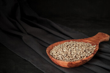 Shelled sunflower seeds in wooden spoon