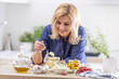 © weyo - Smiling blonde woman takes spoonful of crushed garlic during preserves making session in the autumn