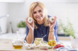 © weyo - Woman holds garlic heads in her hands while various types of garlic preserves surround her