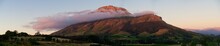 Panoramic View Of The Stellenbosch Mountains Over Green Fields Under Cloudy Sky In South Africa