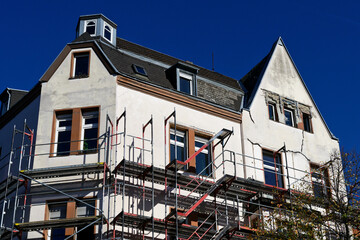 scaffolded old damaged building with cracks in the facade