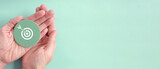 Hand holding target paper cut, achieve on point, sustianable challenge goal, business objective plan concept